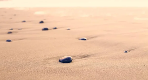 small rocks on the sandy beach