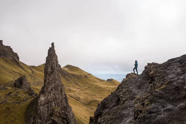 portrait of a young couple holding hands on mountain terrain.