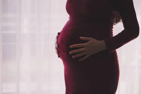 woman in red dress with big baby belly