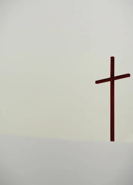 Brown Cross in winter snow with copy space