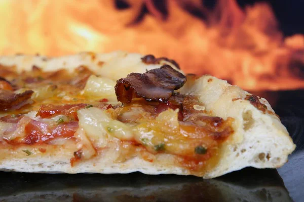 close up of baked Pizza  with fire on the background