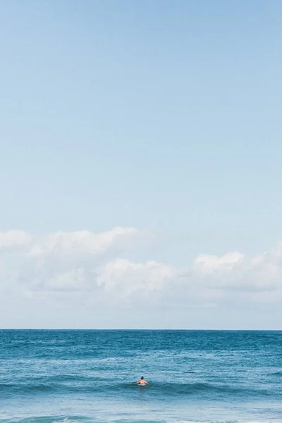 person swimming in the sea  at the day time