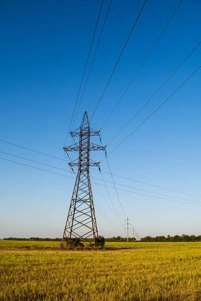 Electric Supply tower on grass at daytime