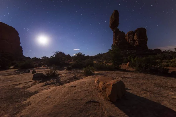 Land with brown rocks in night with full moon