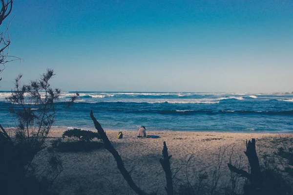 Sitting Alone on the beach near the shore