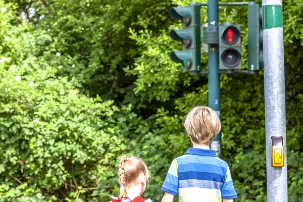 Boy and girl waiting at the red traffic light — Stock Photo, Image