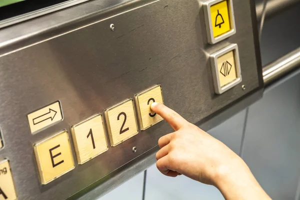 Meisje drukken op de knoppen van een lift — Stockfoto