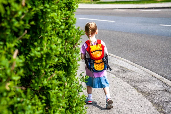 Little girls walking away with her filled backpack — Stock Photo, Image