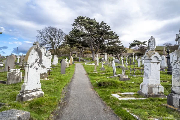 Llandudno, Wales, Wielka Brytania - 22 kwietnia 2018: Dramtic grobów stojący w St Tudnos Kościół i cmentarz na Great Orme w Llandudno, Wales, Wielka Brytania — Zdjęcie stockowe