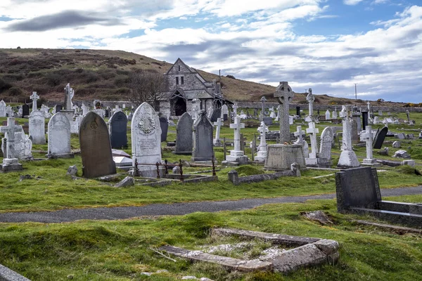 Llandudno, Wales, Wielka Brytania - 22 kwietnia 2018: Dramtic grobów stojący w St Tudnos Kościół i cmentarz na Great Orme w Llandudno, Wales, Wielka Brytania — Zdjęcie stockowe