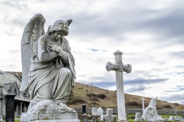 Llandudno , Wales, UK - April 22 2018 : Dramatic graves standing at St Tudnos church and cemetery on the Great Orme at Llandudno, Wales, UK clipart