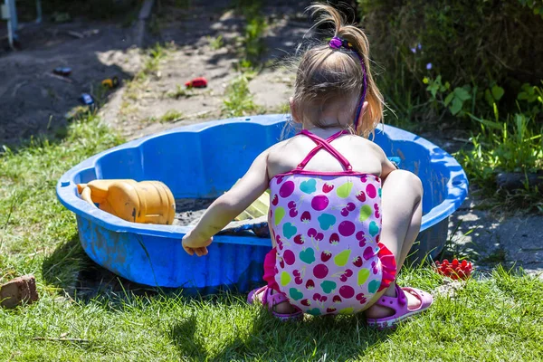 Liebenswertes kleines Mädchen spielt im Sandkasten — Stockfoto