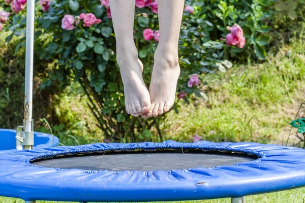 Pojken hoppar på studsmatta i bakgård — Stockfoto