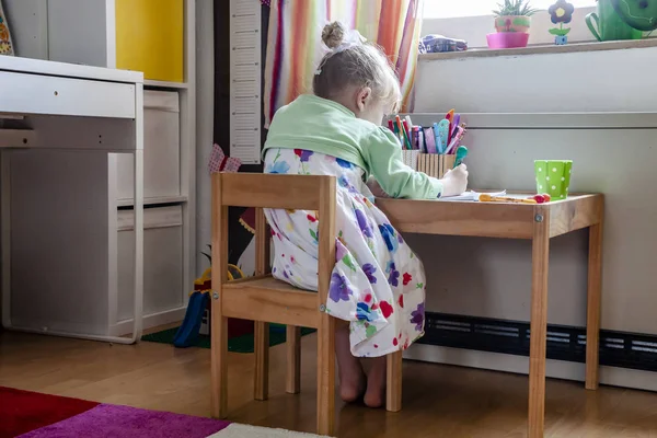Милая маленькая девочка рисует в своей комнате дома — стоковое фото