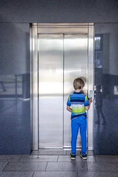 Küçük çocuk asansörü çağırıyor