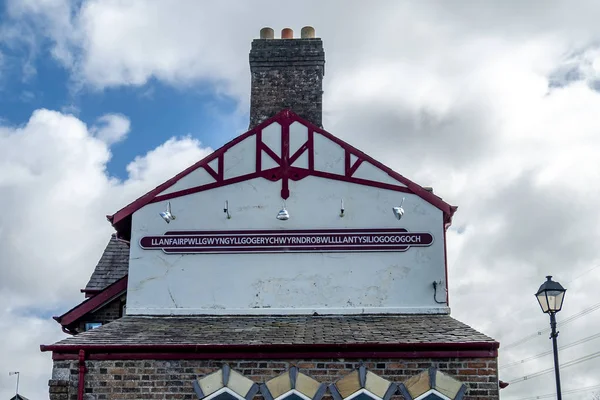 The longest place name of the UK, llanfairpwllgwyngyllgogerychwyrndrobwllllantysiliogogogogogoch on the public train station — стоковое фото