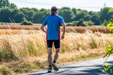 Hasat zamanı sırasında alanının yanındaki koşan adam