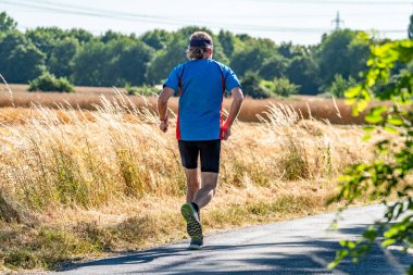 Hasat zamanı sırasında alanının yanındaki koşan adam