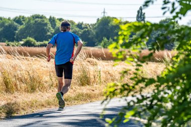 Hasat zamanı sırasında alanının yanındaki koşan adam