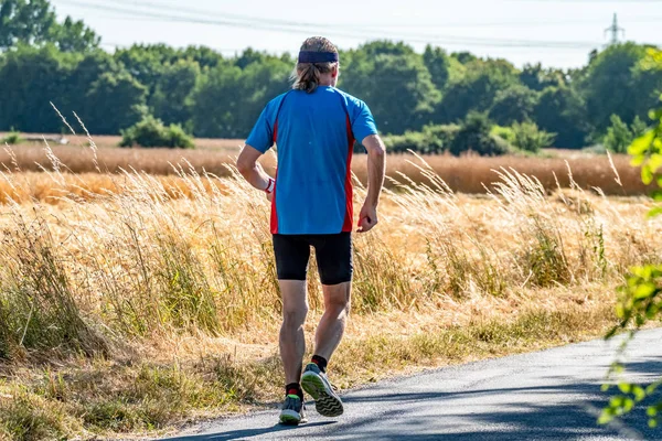 Hasat zamanı sırasında alanının yanındaki koşan adam