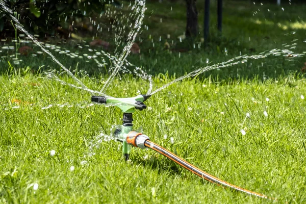 Sprinkler of automatic watering system working in the hot summer — Stock Photo, Image