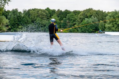 Çocuk gölde su kayağı ile eğleniyor