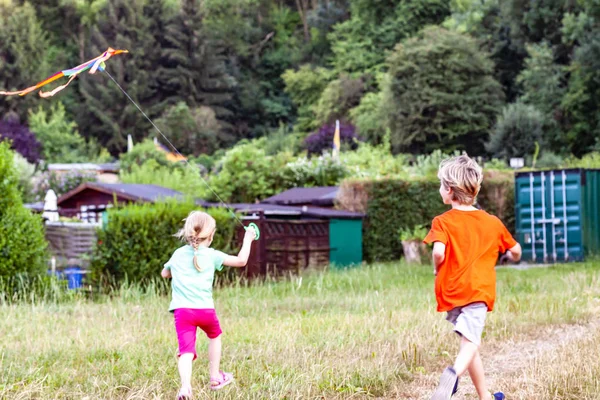 Pojke och flicka ha kul flyger en drake i sommar — Stockfoto