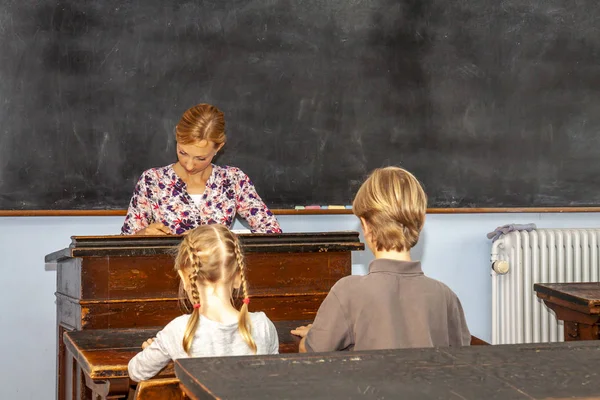 Koncepcja edukacji publicznej szkoły podstawowej z młody chłopak i dziewczyna słuchanie Nauczycielka — Zdjęcie stockowe