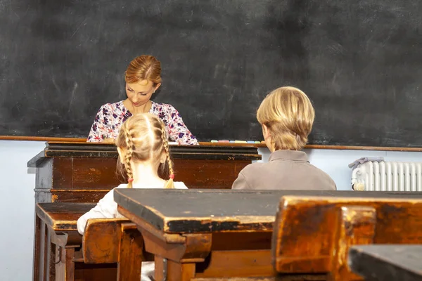 Concepto de educación primaria pública con niños y niñas escuchando a la maestra —  Fotos de Stock