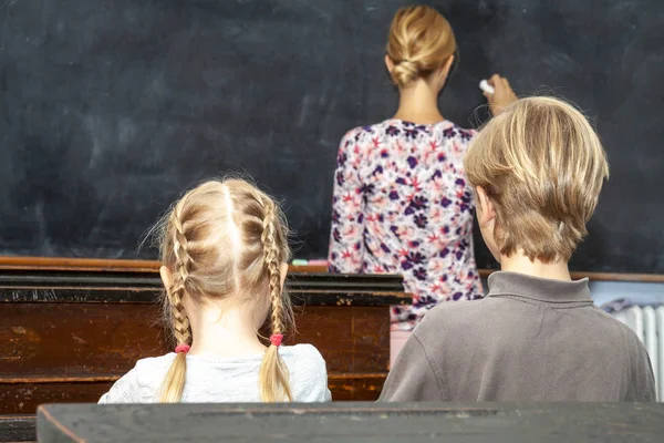 Concepto de educación primaria pública con niños y niñas escuchando a la maestra —  Fotos de Stock