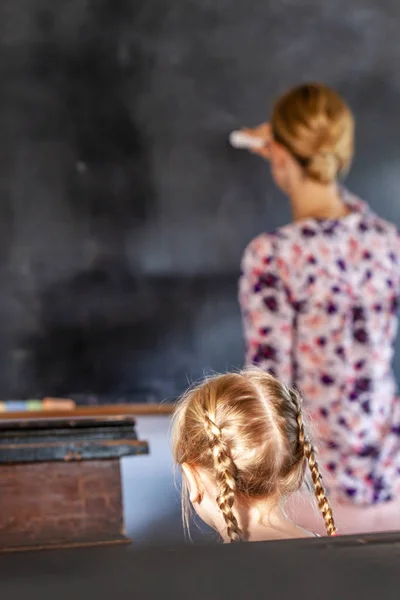 Konzept der öffentlichen Grundschulerziehung mit jungen Mädchen, die der Lehrerin zuhören — Stockfoto