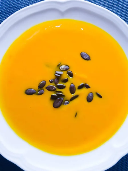 Тыквенный суп с тыквенными семечками, готовый к употреблению на тарелке — стоковое фото