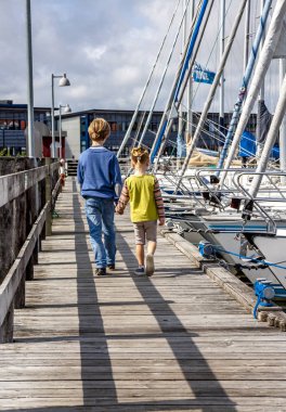 Ringkobing, Danimarka - 15 Ağustos 2018: Kardeşi ve kız kardeşi el içinde el ve liman yürüyüş