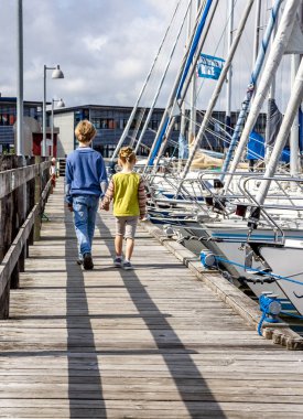Ringobing, Danimarka - 15 Ağustos 2018: Kardeşi ve kız kardeşi el içinde el ve liman yürüyüş