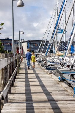 Ringkobing, Danimarka - 15 Ağustos 2018: Kardeşi ve kız kardeşi el içinde el ve liman yürüyüş