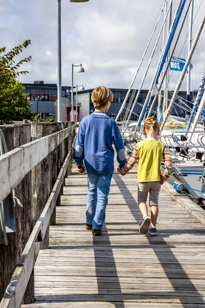 Ringkobing, Dánsko - 15 srpna 2018: Bratr a sestra procházky ruku v ruce v přístavu — Stock fotografie