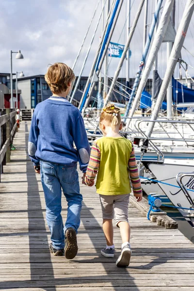 Ringkobing, Danimarka - 15 Ağustos 2018: Kardeşi ve kız kardeşi el içinde el ve liman yürüyüş