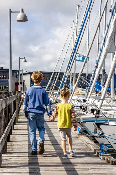 Ringkobing, Dánsko - 15 srpna 2018: Bratr a sestra procházky ruku v ruce v přístavu — Stock fotografie