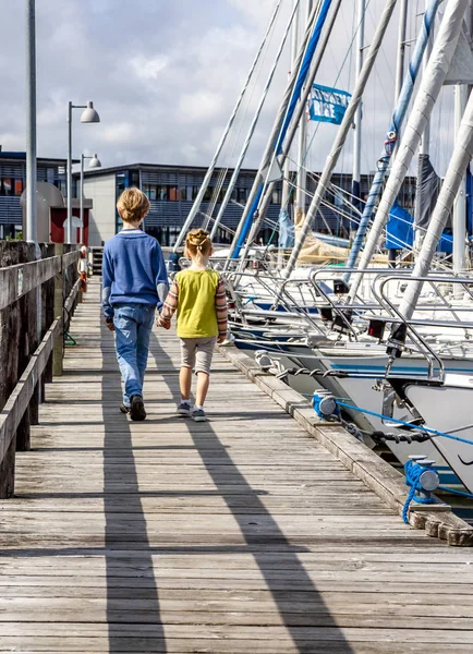 Ringobing, Danimarka - 15 Ağustos 2018: Kardeşi ve kız kardeşi el içinde el ve liman yürüyüş