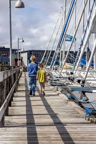 Ringkobing, Danimarka - 15 Ağustos 2018: Kardeşi ve kız kardeşi el içinde el ve liman yürüyüş