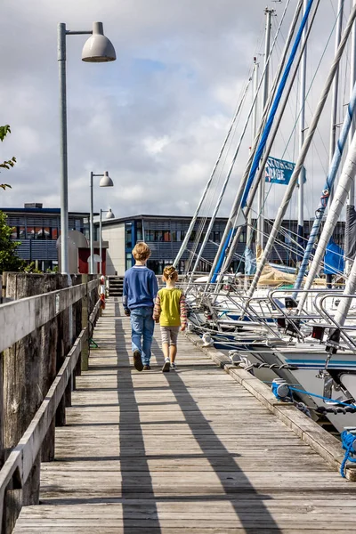 Ringkobing, Danimarka - 15 Ağustos 2018: Kardeşi ve kız kardeşi el içinde el ve liman yürüyüş
