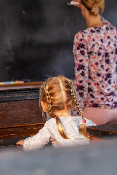 Konzept der öffentlichen Grundschulerziehung mit jungen Mädchen, die der Lehrerin zuhören — Stockfoto