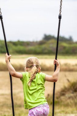 Küçük kız salıncak açık duran eğlenceli olması