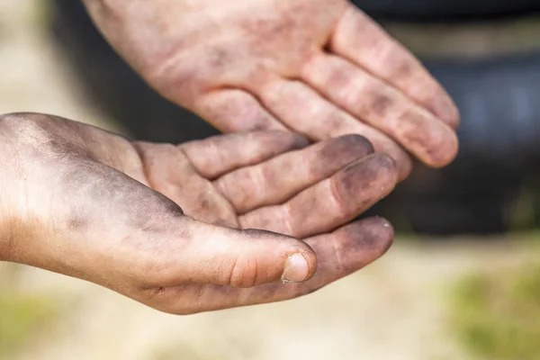 Närbild av ung man smutsiga händer och däck utomhus — Stockfoto