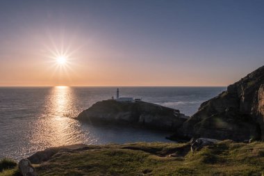 Galler'de Anglesey Güney yığın deniz feneri günbatımı