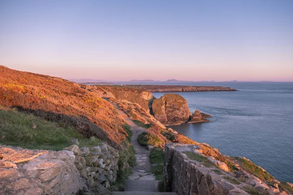 Naplemente a sziklák, a déli verem világítótorony, Anglesey, Wales — Stock Fotó