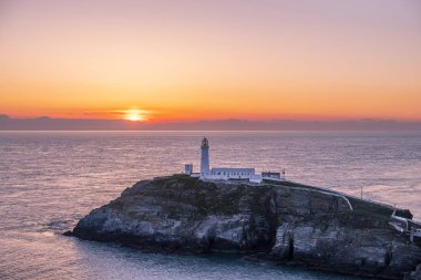 Galler'de Anglesey Güney yığın deniz feneri günbatımı