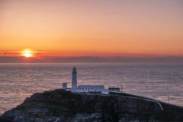 Pôr do sol no farol pilha sul em Anglesey, no País de Gales — Fotografia de Stock