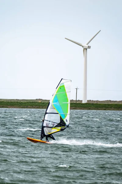 Homem windsurf perto da cidade de Caernarfon no País de Gales - Reino Unido — Fotografia de Stock