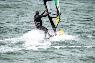 Man windsurfing close to the town of Caernarfon in Wales - United Kingdom clipart